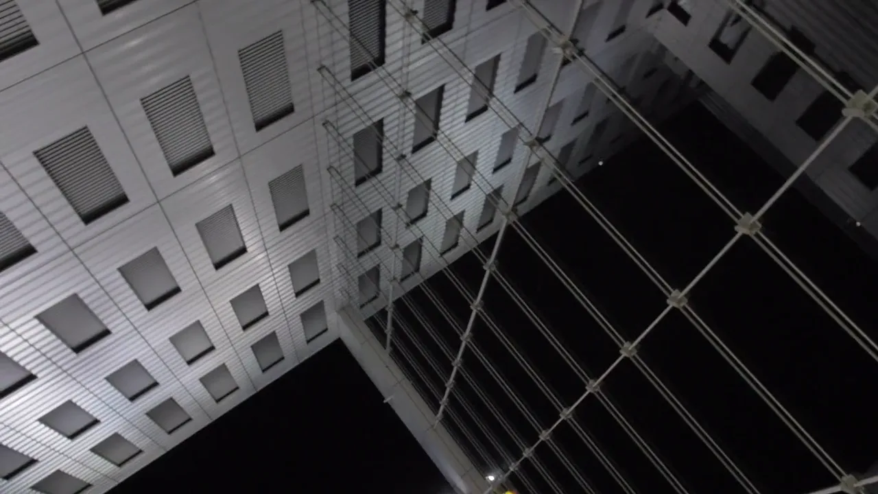 Geometric building facades reflected in glass.